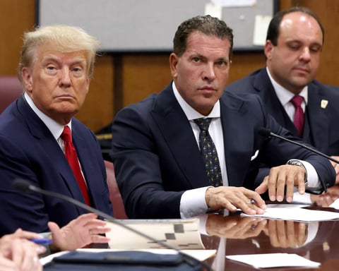 President Donald Trump sits with his attorneys Joe Tacopina and Boris Epshteyn