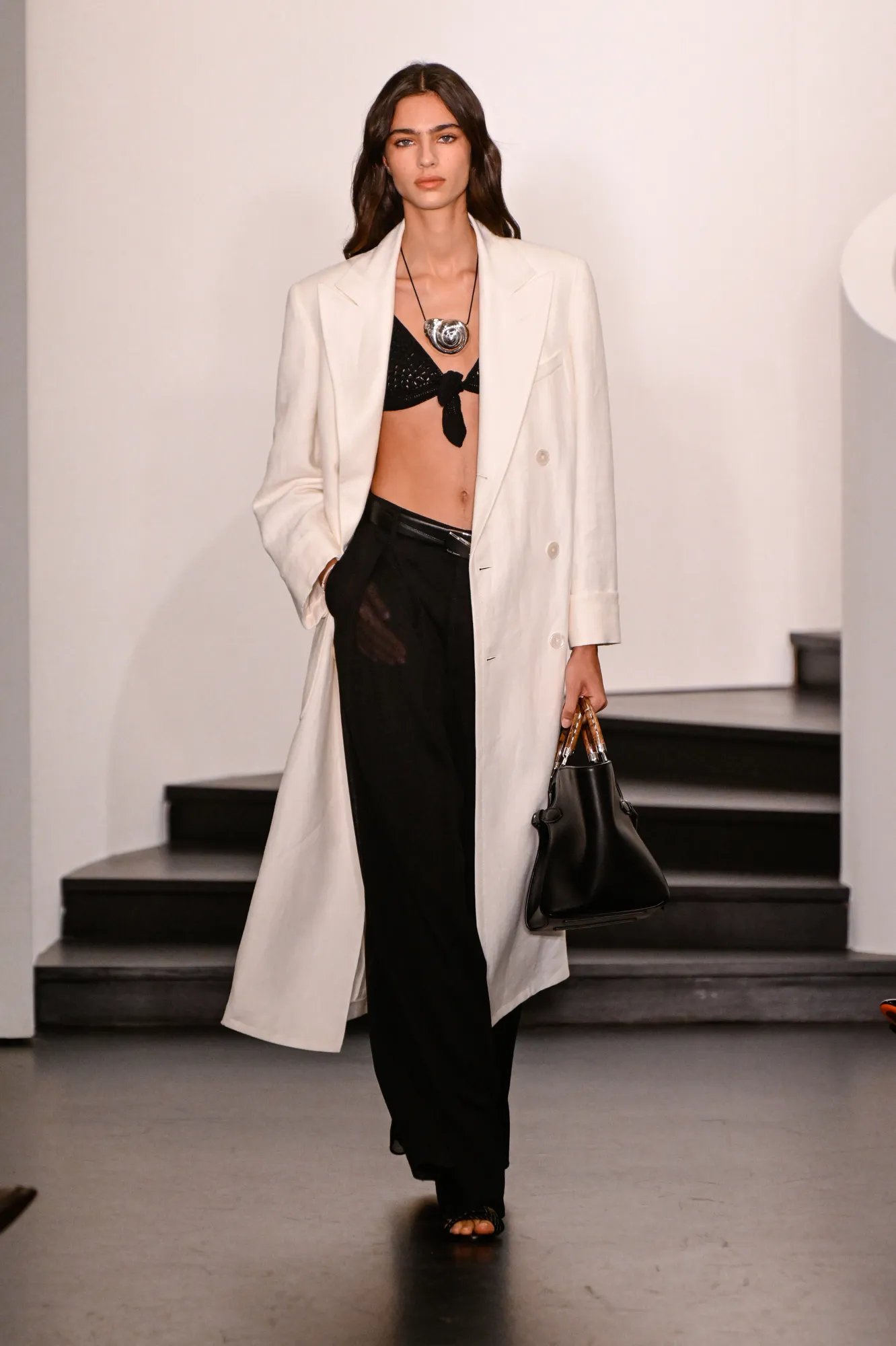 Ralph Lauren Spring 2026 monochrome look with black bra, white coat and black trousers at New York Fashion Week