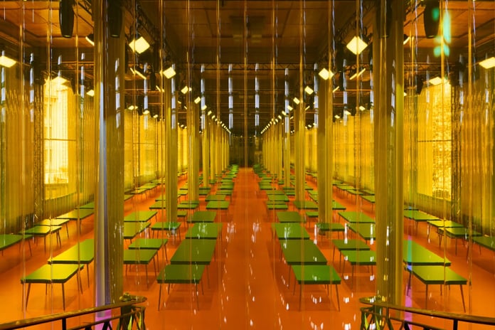 Inside Palais d’Iéna during Miu Miu Spring 2026 with tables across the show space