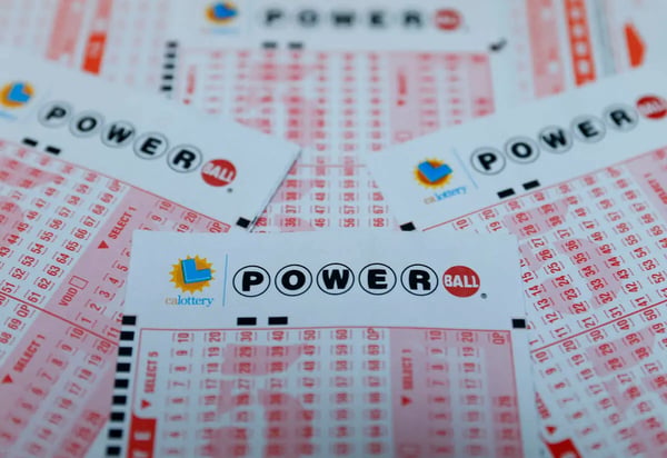 Powerball lottery ticket with $1.7 billion jackpot displayed alongside cash money for Christmas Eve 2024 drawing