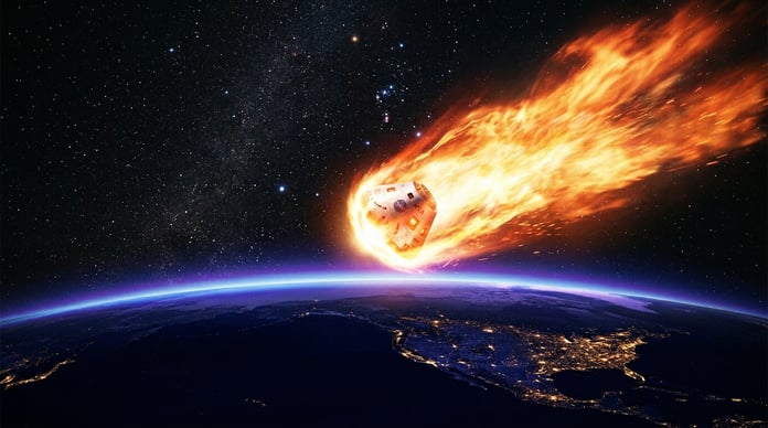 Orion spacecraft during Artemis II reentry glowing with plasma heat shield over Earth
