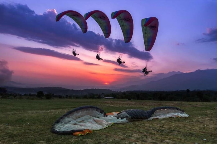 Paragliders flying over Bir Billing with Dhauladhar mountains in Himachal Pradesh