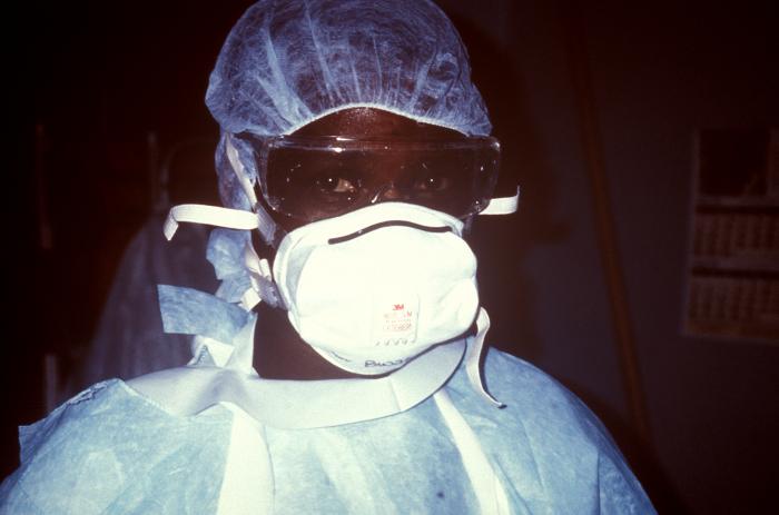 A nurse in full personal protective equipment prepares to enter an Ebola isolation ward