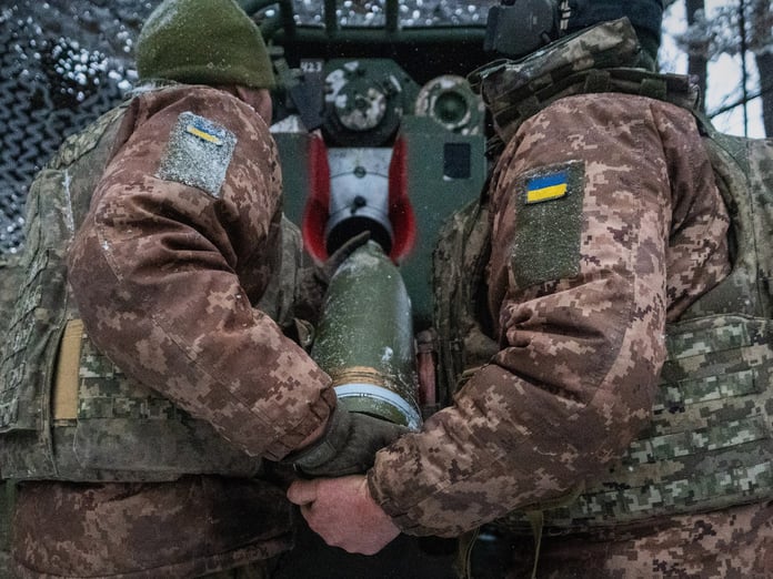 Ukrainian servicemen load an artillery shell on the Kharkiv front during the Russia-Ukraine war