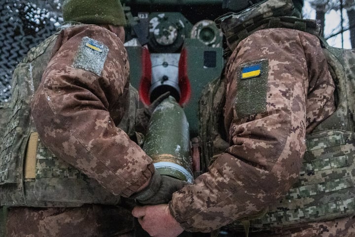 Ukrainian servicemen load an artillery shell on the Kharkiv front during the Russia-Ukraine war