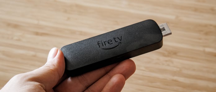 Amazon Fire TV Stick 4K Select streaming device held in hand showing compact HDMI dongle design