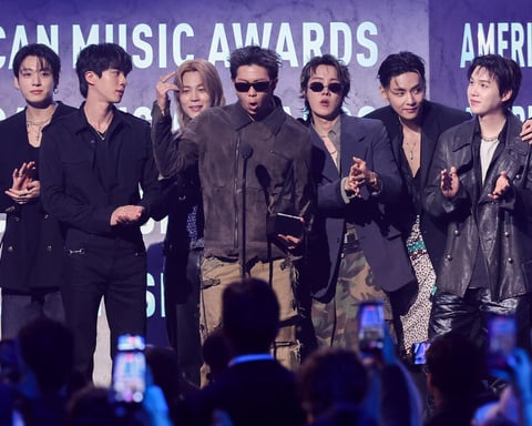 BTS members accepting the Artist of the Year award on stage at the 2026 American Music Awards at MGM Grand Garden Arena in Las Vegas
