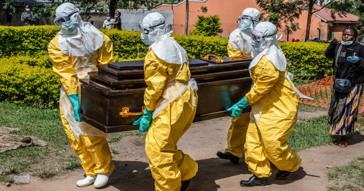 Red Cross workers in protective gear carry the coffin of Dr. Tibenderana Katho Blaise who died of Ebola in Bunia Democratic Republic of Congo