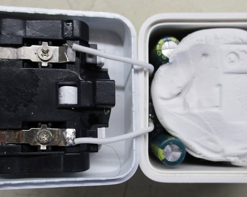 Opened counterfeit phone charger revealing modelling clay inside, found by Which? in 2026 investigation into unsafe products sold on Amazon and eBay