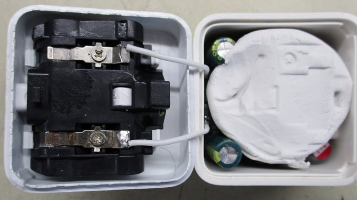 Opened counterfeit phone charger revealing modelling clay inside, found by Which? in 2026 investigation into unsafe products sold on Amazon and eBay