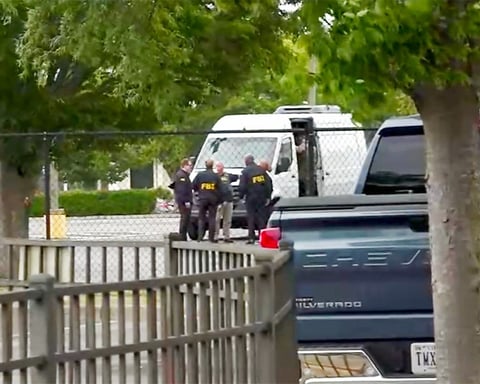 FBI agents carry out a search of an office during a federal operation