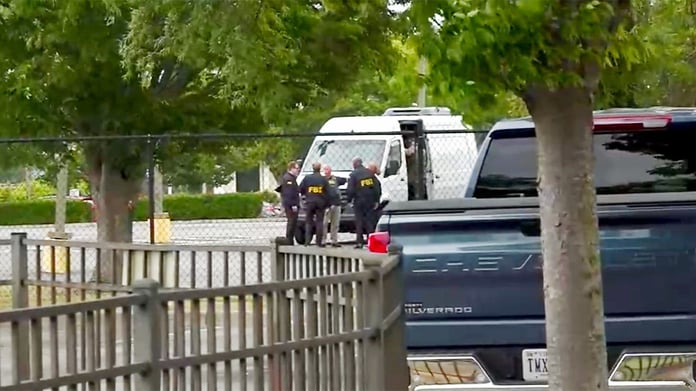 FBI agents carry out a search of an office during a federal operation