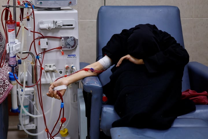 A Palestinian woman with kidney failure undergoes dialysis in Gaza while hoping to leave for treatment abroad