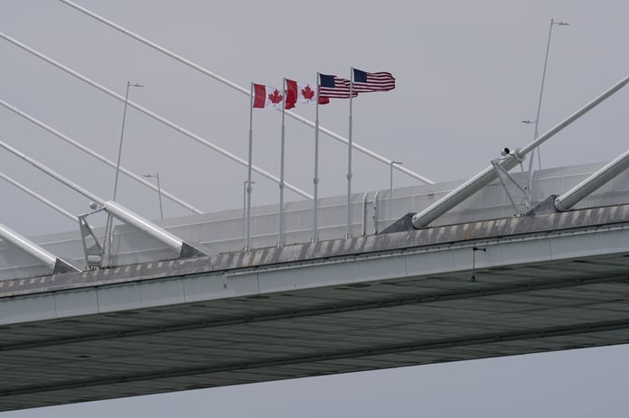 Canadian and US flags fly on the Gordie Howe International Bridge connecting Windsor, Ontario and Detroit