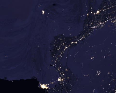 NASA VIIRS satellite image showing the Indus River basin in Pakistan at night with the sinuous shape of the river outlined by the lights of cities Lahore Multan Sukkur and Karachi against the darker desert and mountain landscape