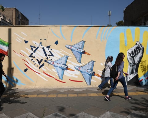 People walk past an anti-Israeli mural on a street in Tehran, June 8, 2026