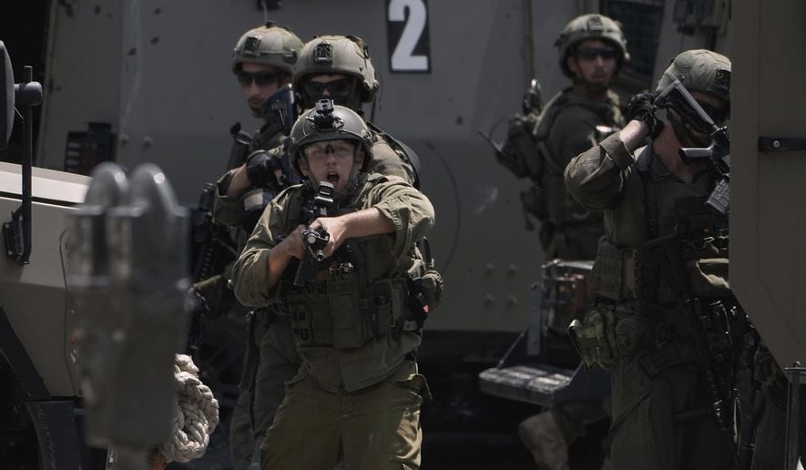 An Israeli soldier points his weapon during a military raid in the West Bank city of Nablus