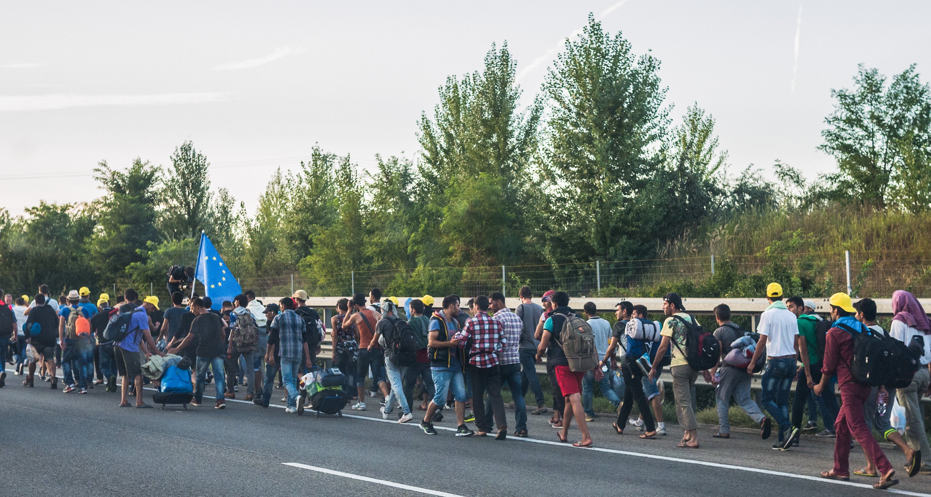 Refugees marching along a road in Europe, the population the EU Migration and Asylum Pact governs