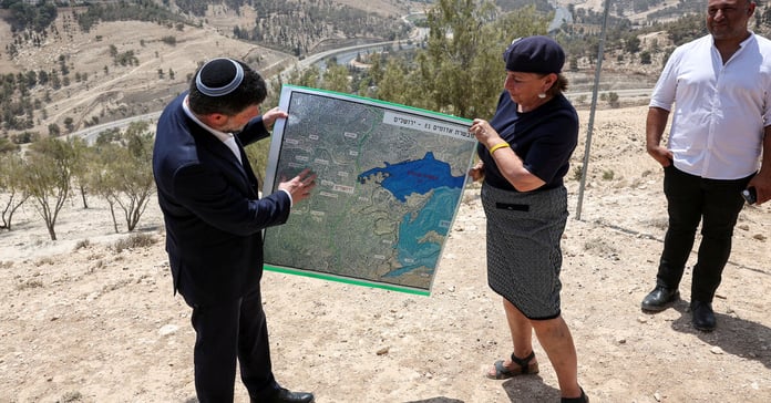 Israeli Finance Minister Bezalel Smotrich holds map of E1 settlement scheme near Maale Adumim in occupied West Bank