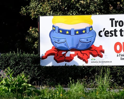 A Swiss People's Party campaign poster reading Enough is enough on a street in Lausanne