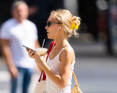 Person wearing wired headphones in urban setting as analog audio revival surges in 2026