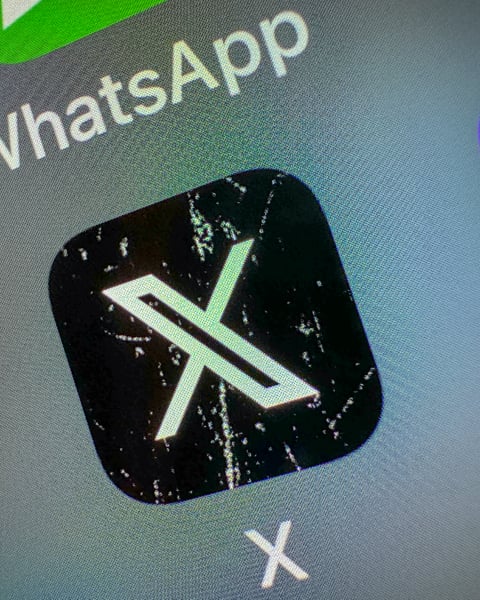 X app icon on smartphone screen showing React with Video feature coming to Android and iOS