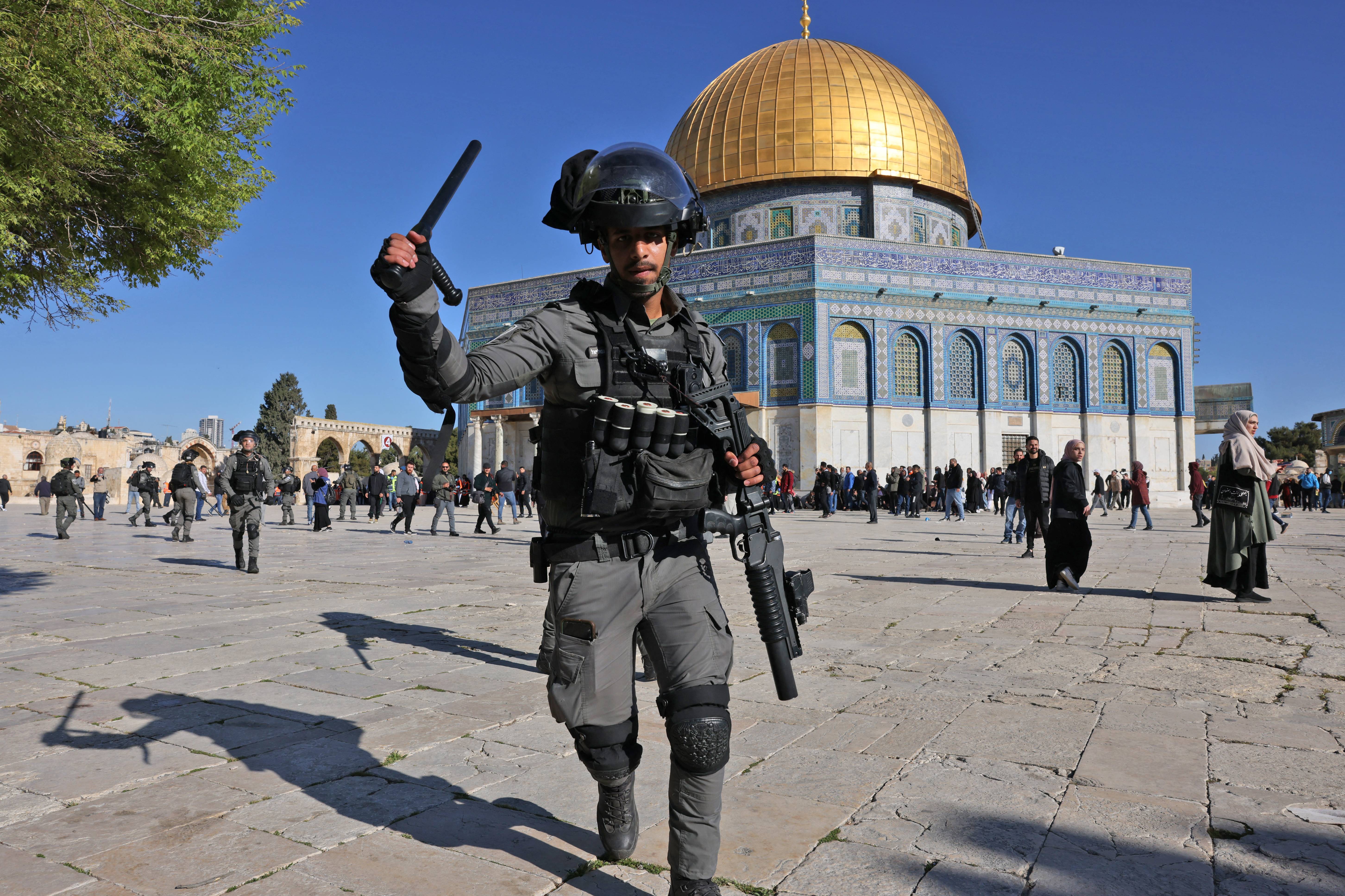 A member of the Israeli security forces lifts his baton