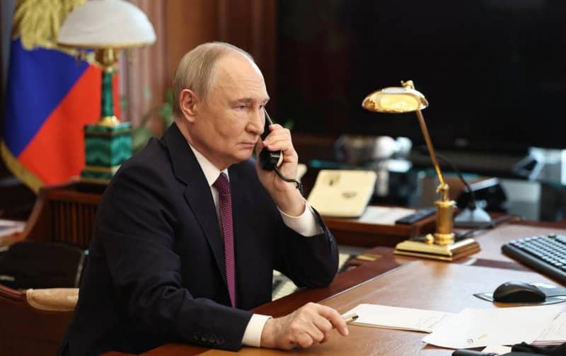 Putin holding phone in his office during call with Ramaphosa on Alaska summit outcomes.