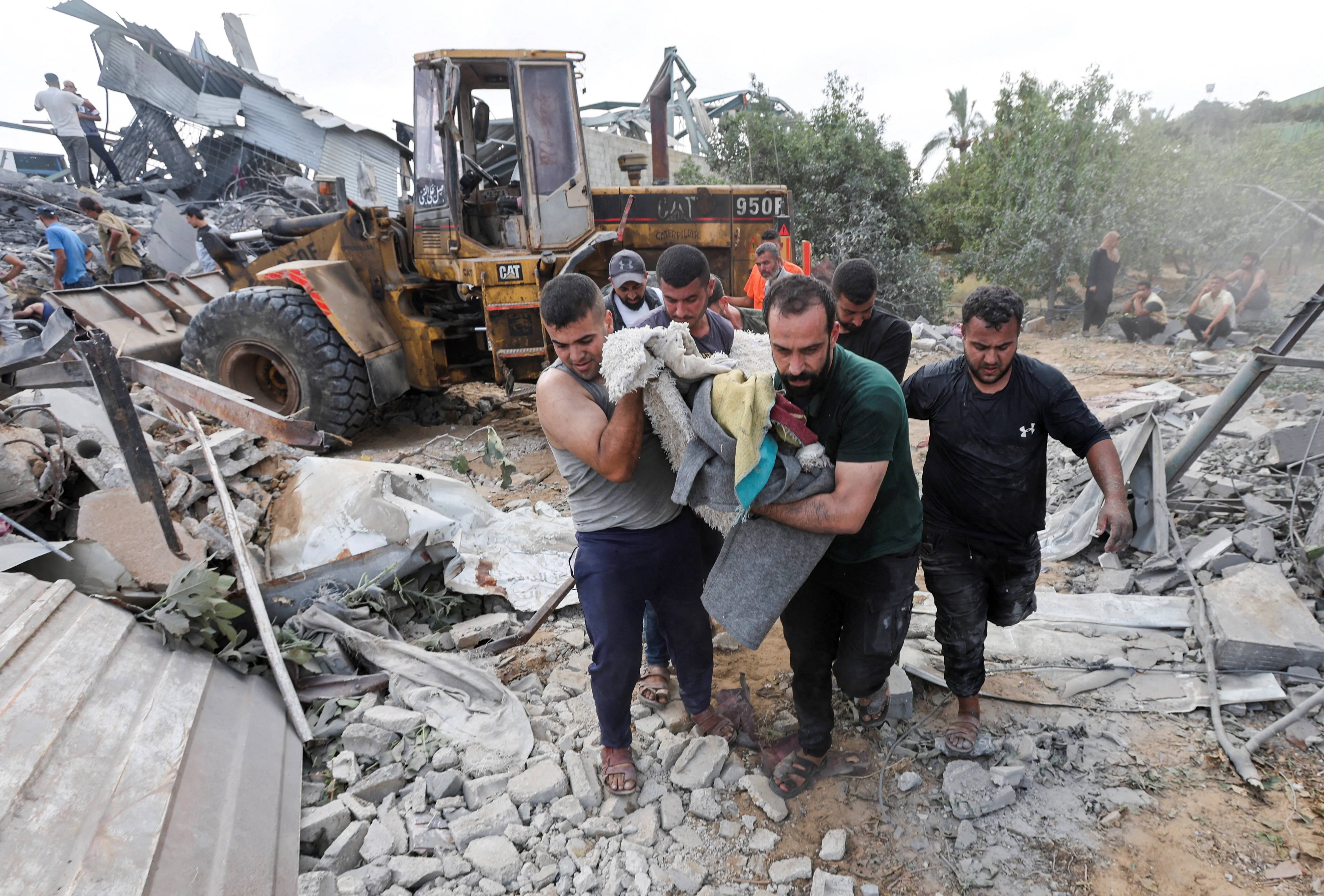 Rescuers search the ruins of a family home in Az-Zawayda after an Israeli airstrike killed 11, including children