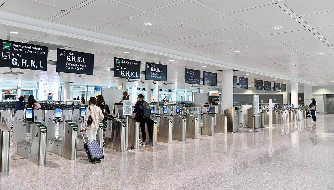 Police walk past a departures board at Munich Airport after drone sightings halt flights