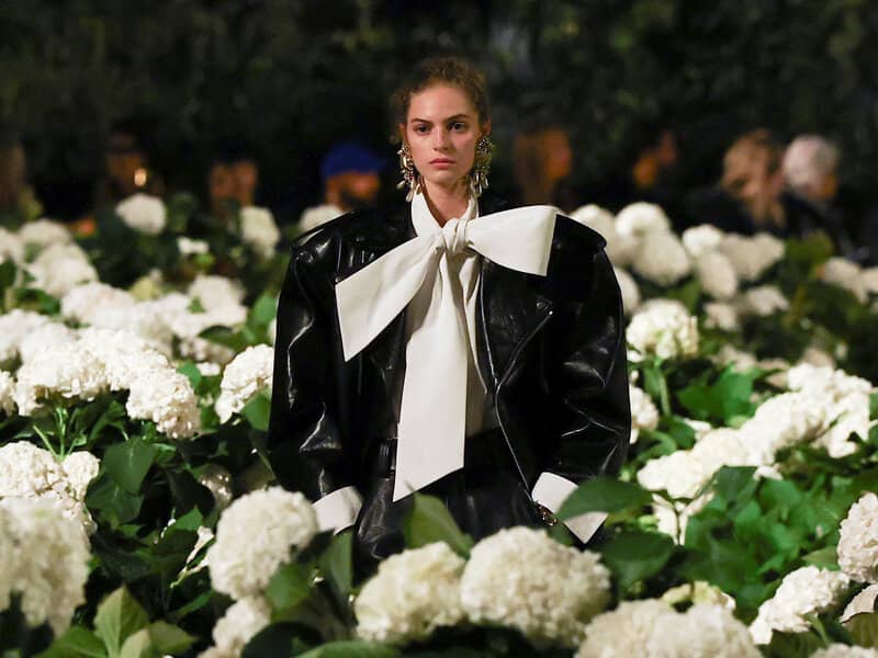 Wide runway view of Saint Laurent with white hydrangea installation at Trocadéro during Paris Fashion Week
