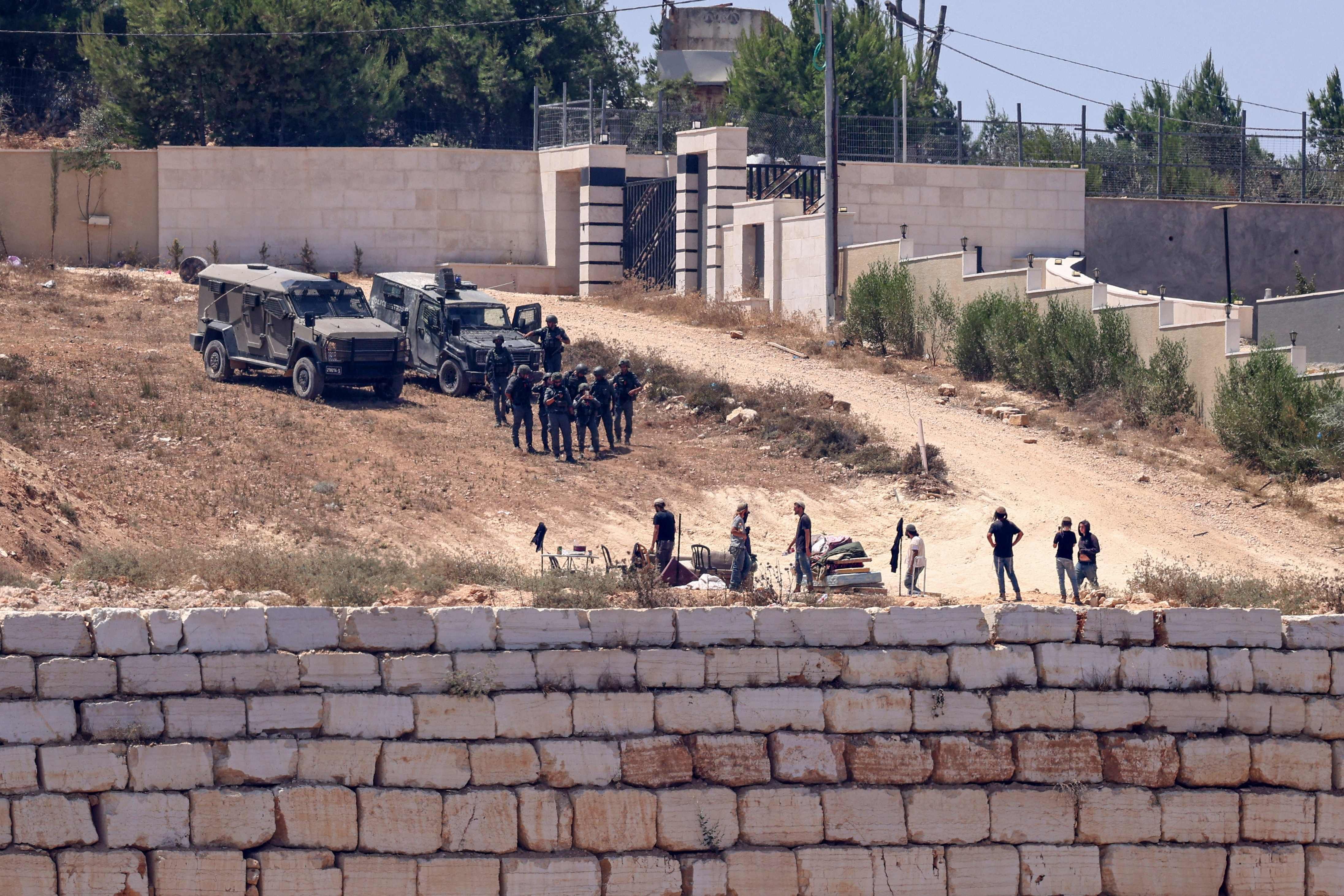 Israeli military forces conduct a raid in the occupied West Bank, imposing a curfew on Palestinian residents