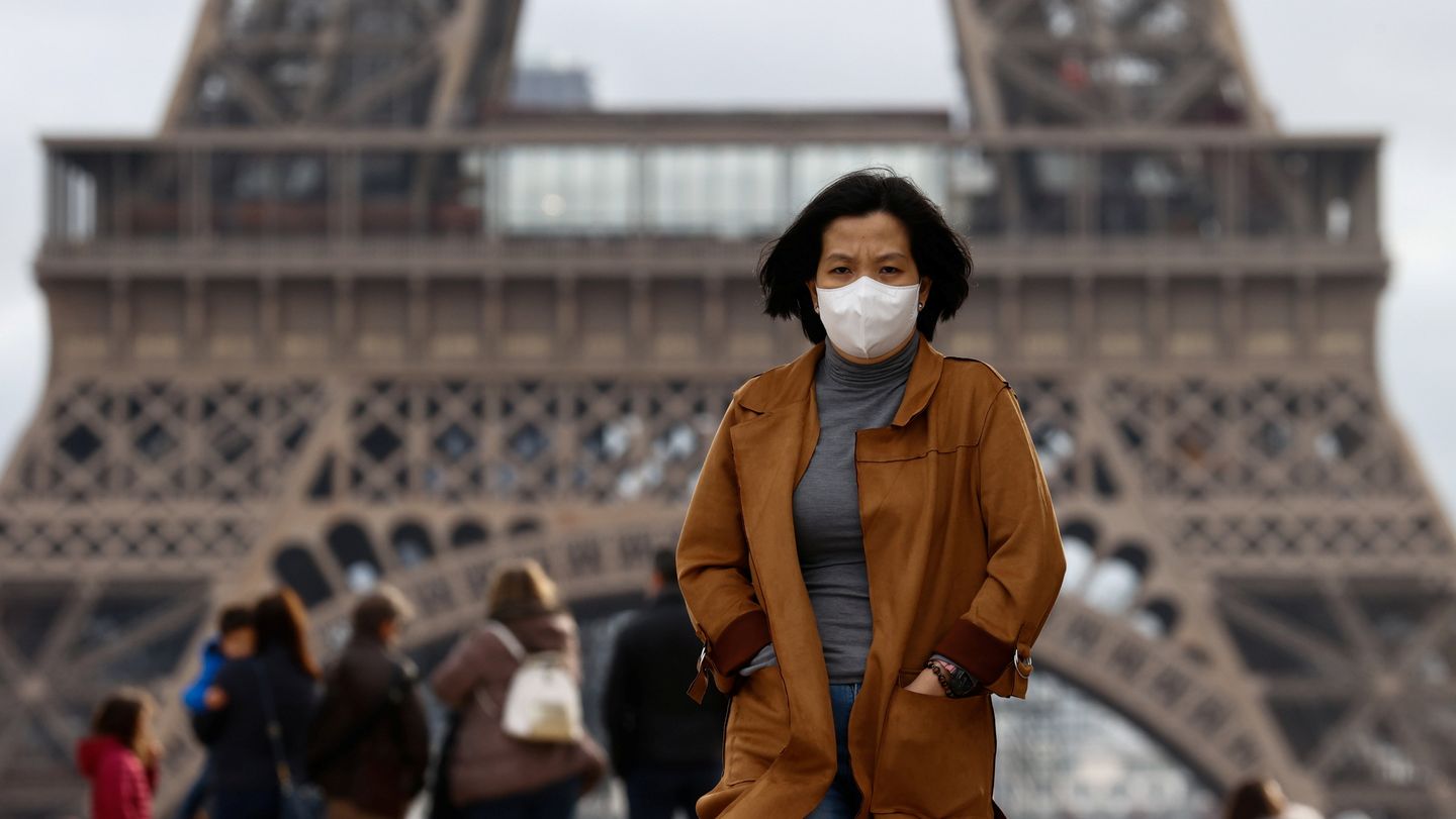 A person wearing a protective face mask near the Eiffel Tower in Paris during the early coronavirus COVID-19 outbreak in France