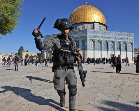 A member of the Israeli security forces lifts his baton