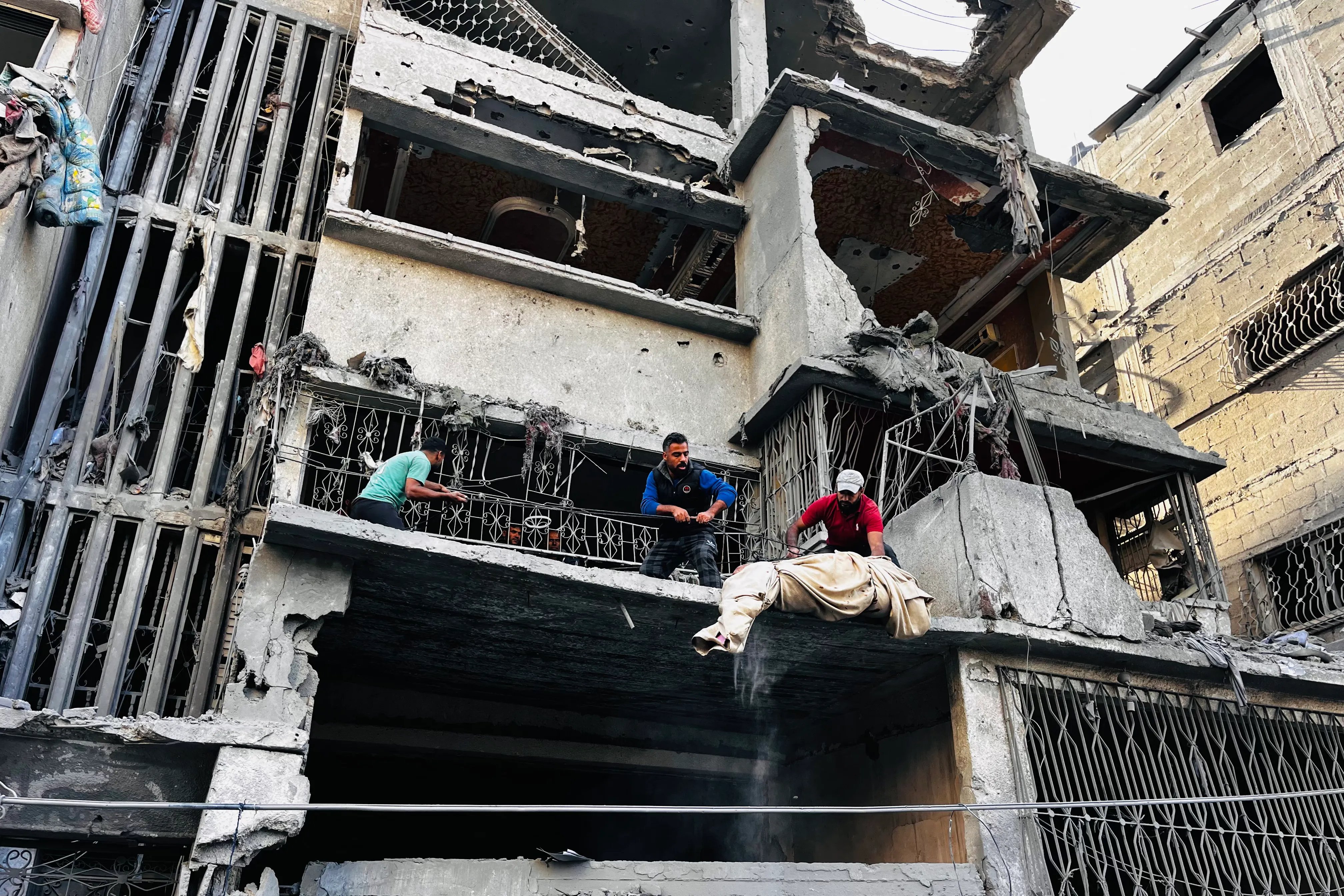 Palestinians remove a body from the rubble of a building following an Israeli strike in Beit Lahiya, Gaza