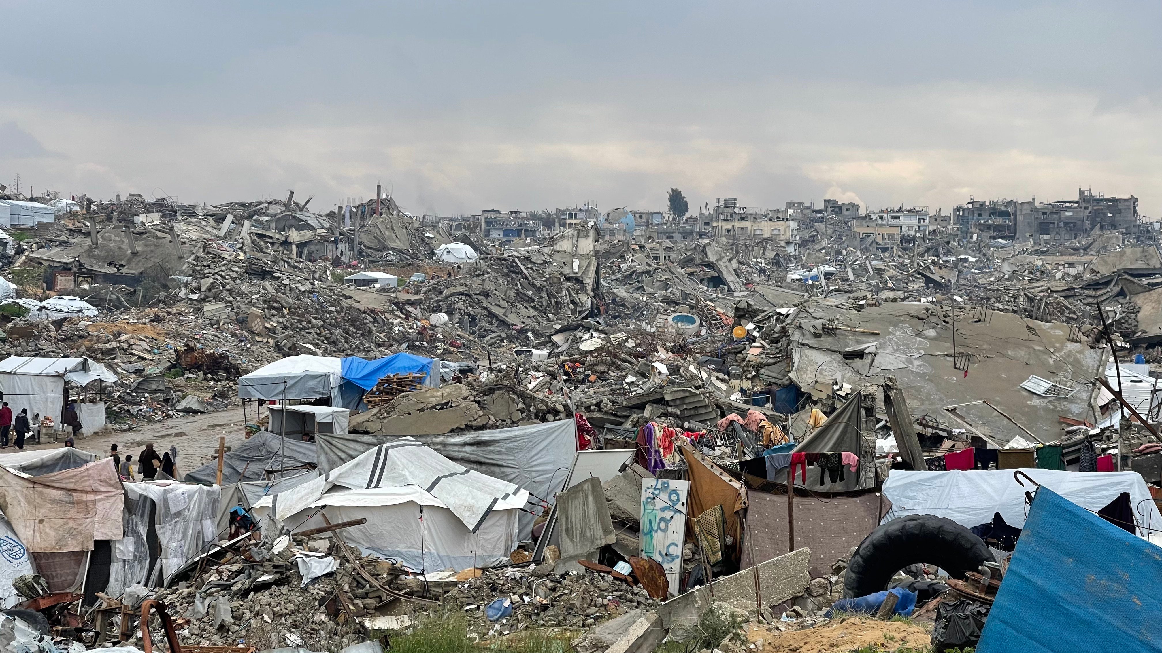 Gaza Destruction And Aid Lines Destroyed buildings in Gaza with civilians queuing for aid amid worsening hunger