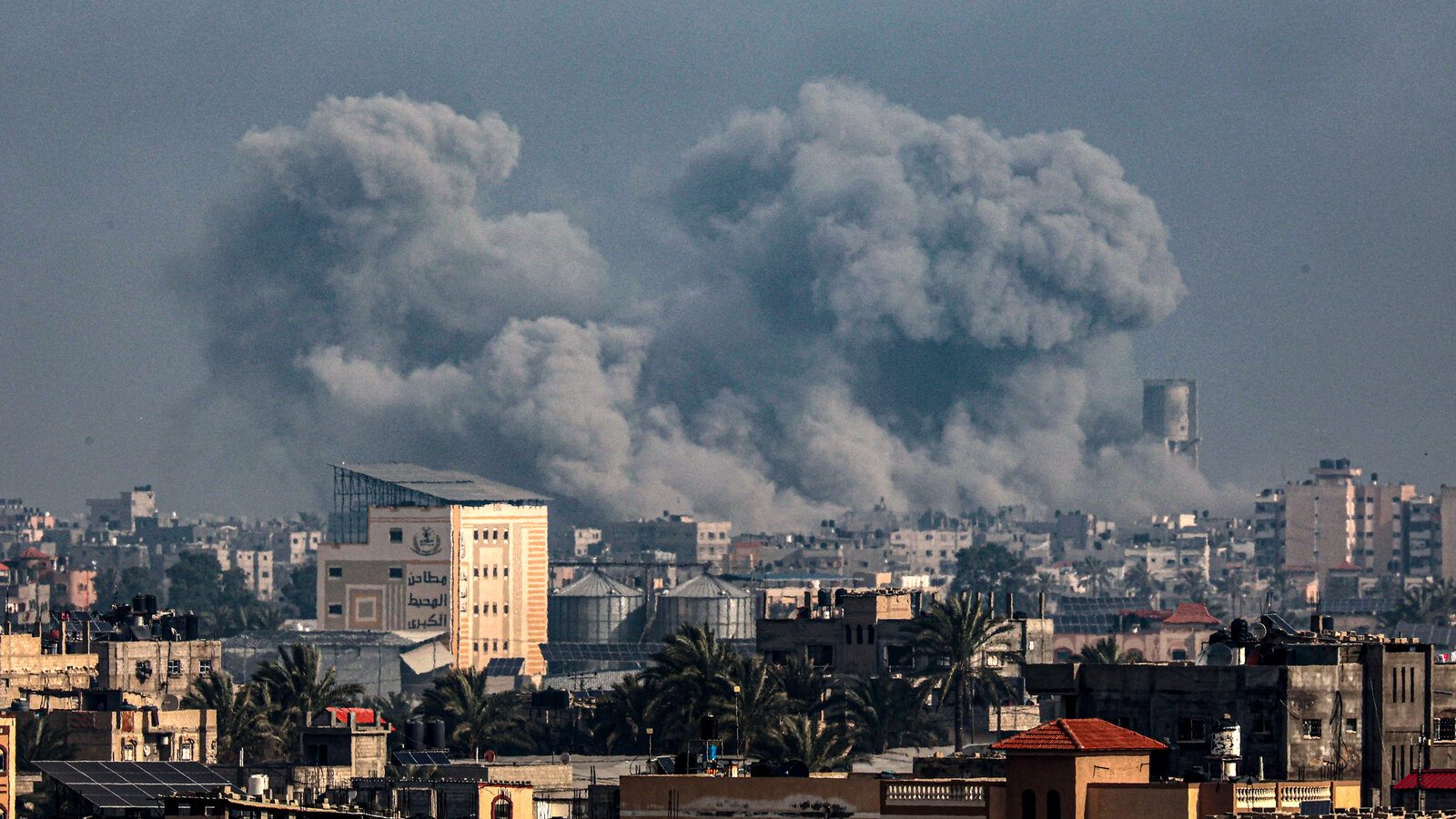 Gaza City skyline with rising smoke plumes during intensified Israeli strikes and ground push as hospitals report critical shortages.