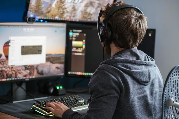 Gen Z workers using laptops and headphones during a hybrid workday