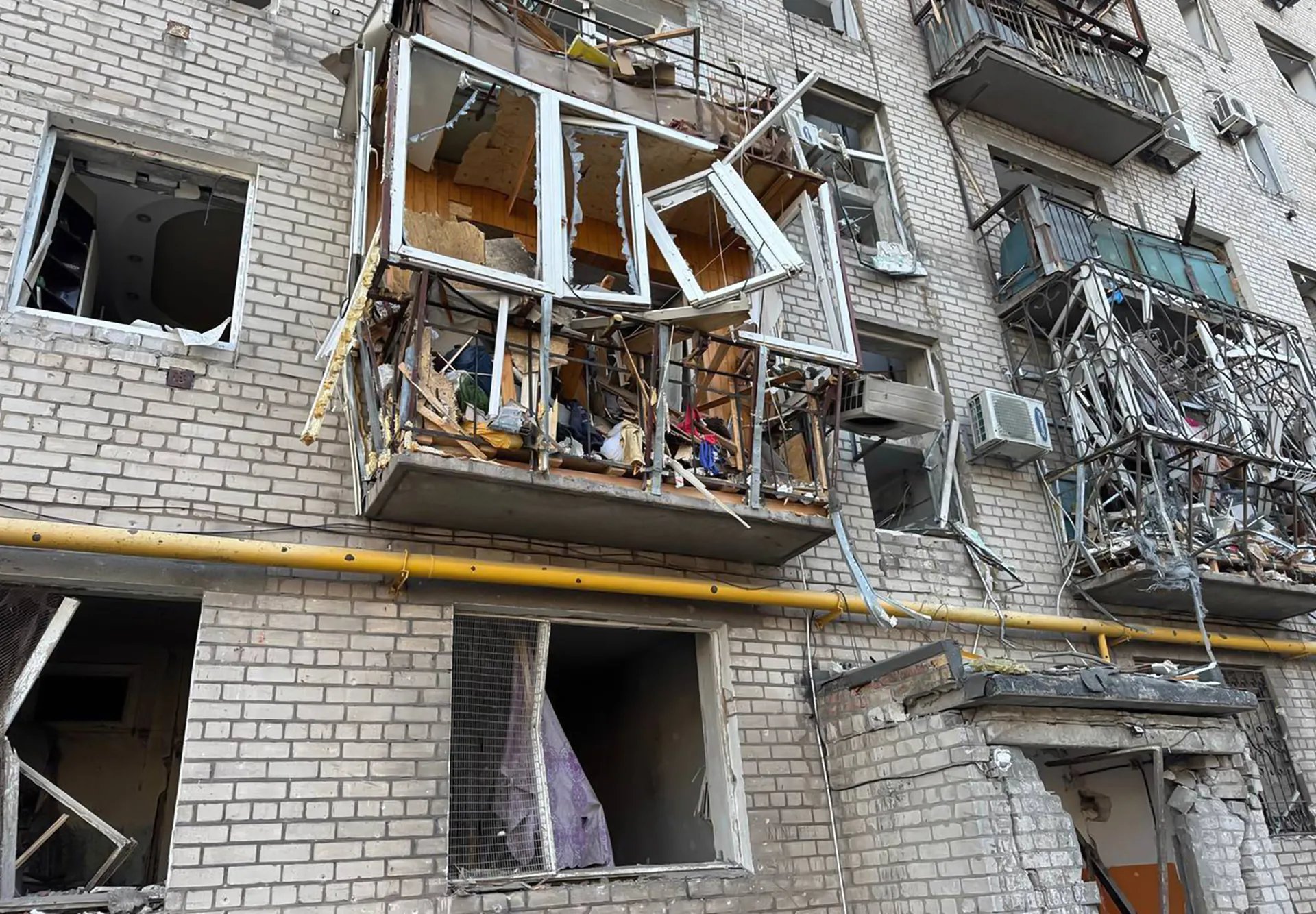 Residents tape plastic over shattered windows aResidents reinforce blown-out windows after the night’s strikes in Kyivfter strikes in Kyiv