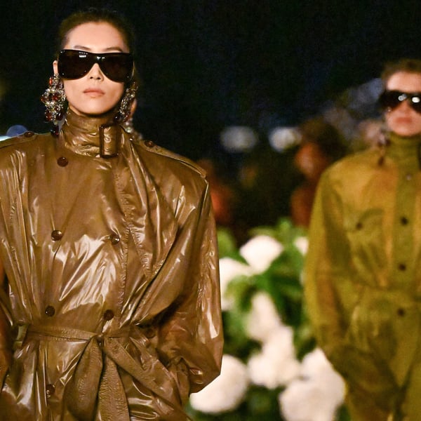 Saint Laurent Spring 2026 at Trocadéro with Eiffel Tower backdrop; model in nylon trench-dress on reflective runway