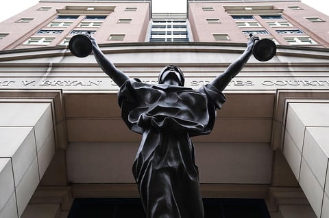 Albert V. Bryan United States Courthouse facade with Justice Delayed statue in Alexandria, Virginia