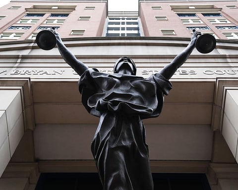 Albert V. Bryan United States Courthouse facade with Justice Delayed statue in Alexandria, Virginia