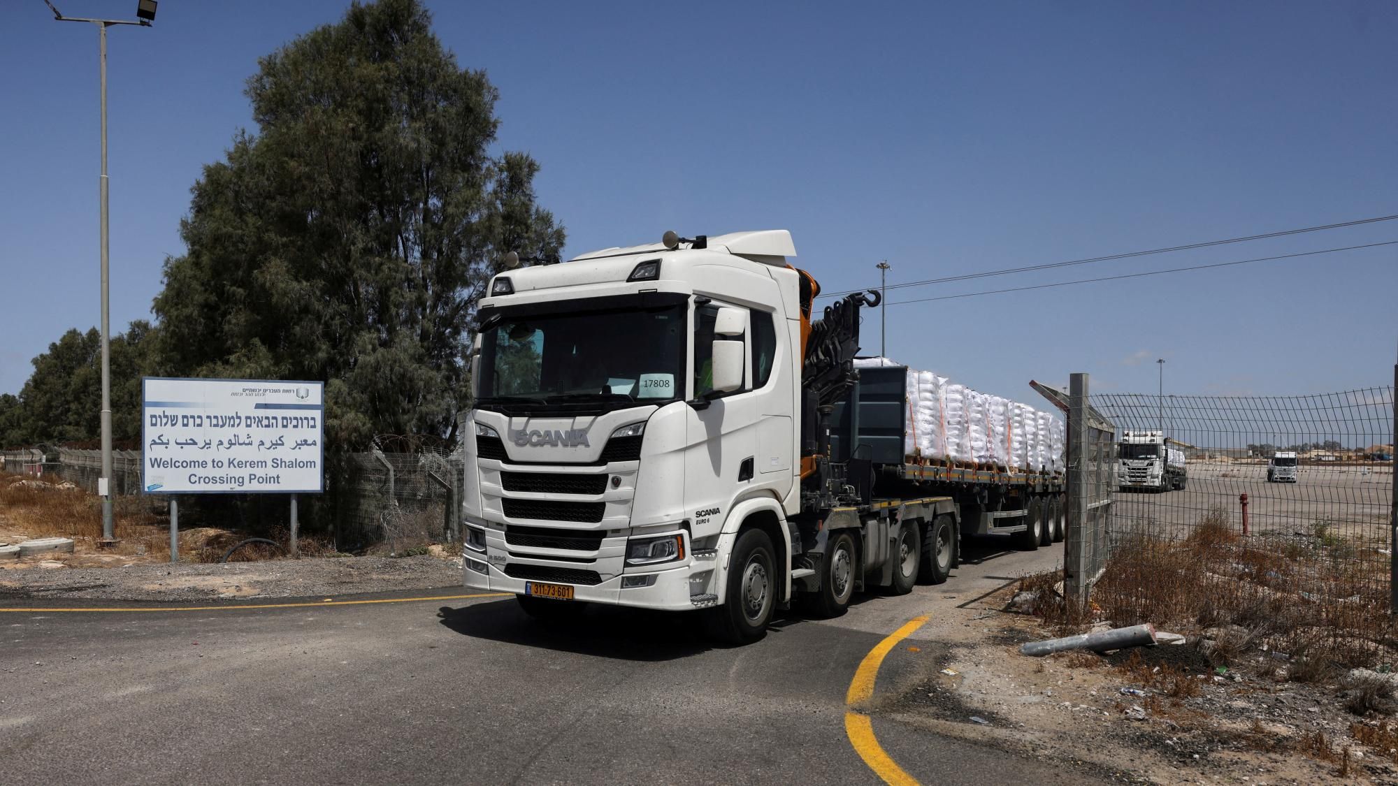 Inspection lanes and posted crossing hours Border inspection lanes with posted hours and signage as trucks line up for checks