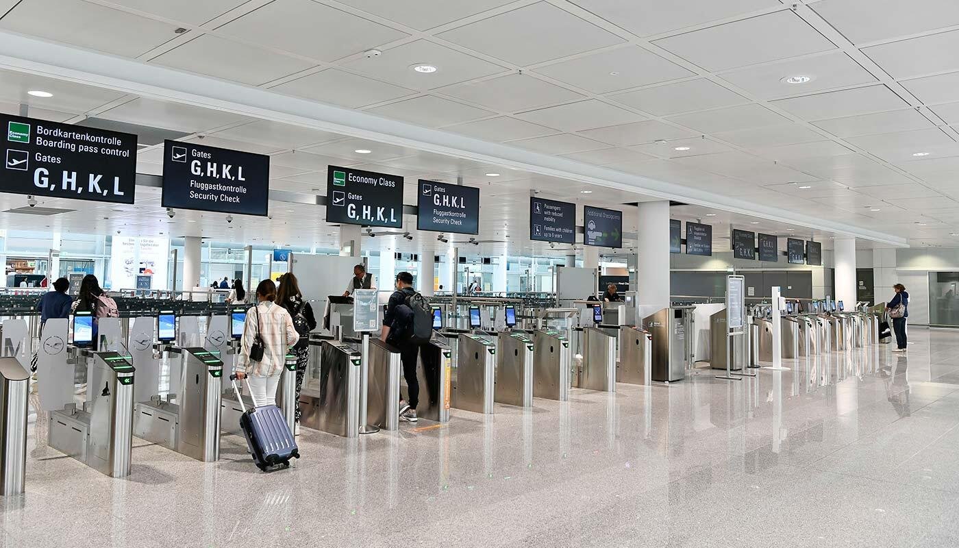 Police walk past a departures board at Munich Airport after drone sightings halt flights