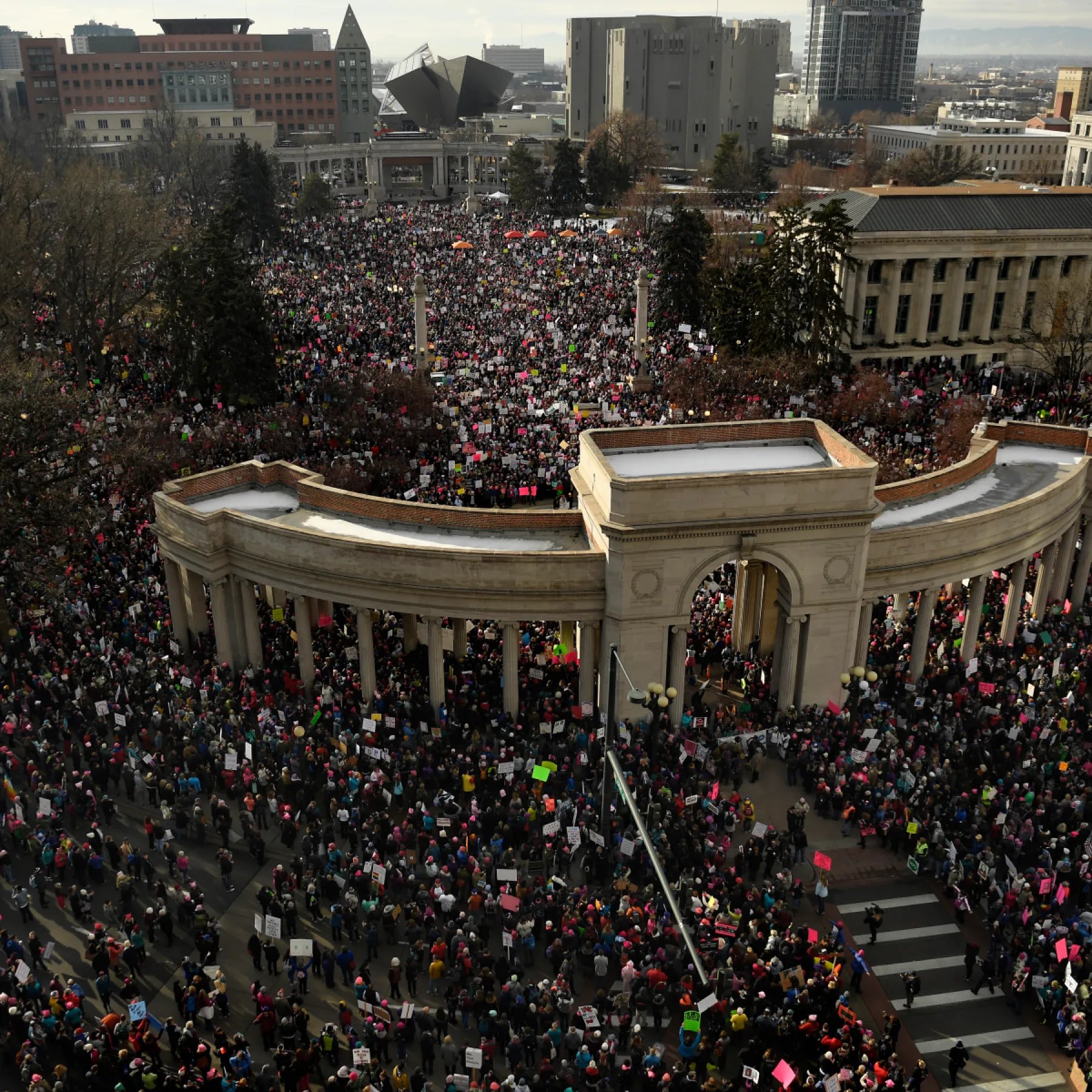 Marchers with handmade signs in Denver’s Civic Center Park
