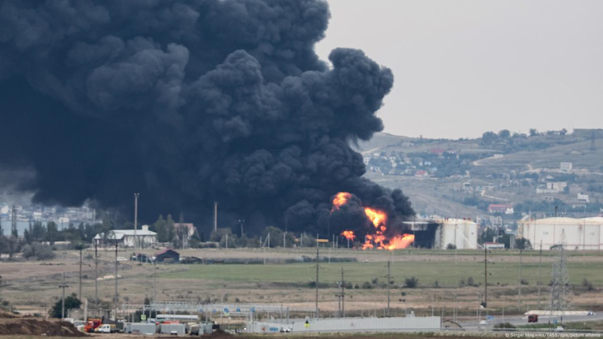 A tall black smoke plume rises from the coastline near the Feodosia oil terminal after a reported strike