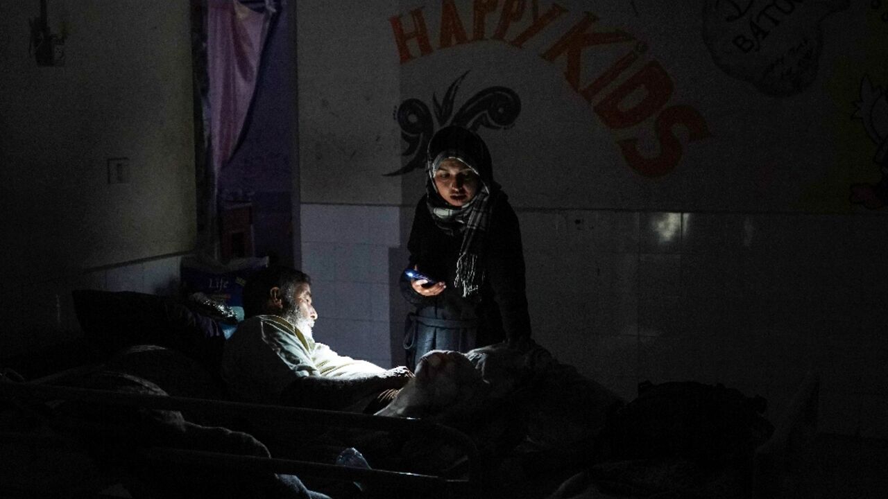 Hospital staff in Gaza check oxygen cylinders beside a generator during overnight power cuts.