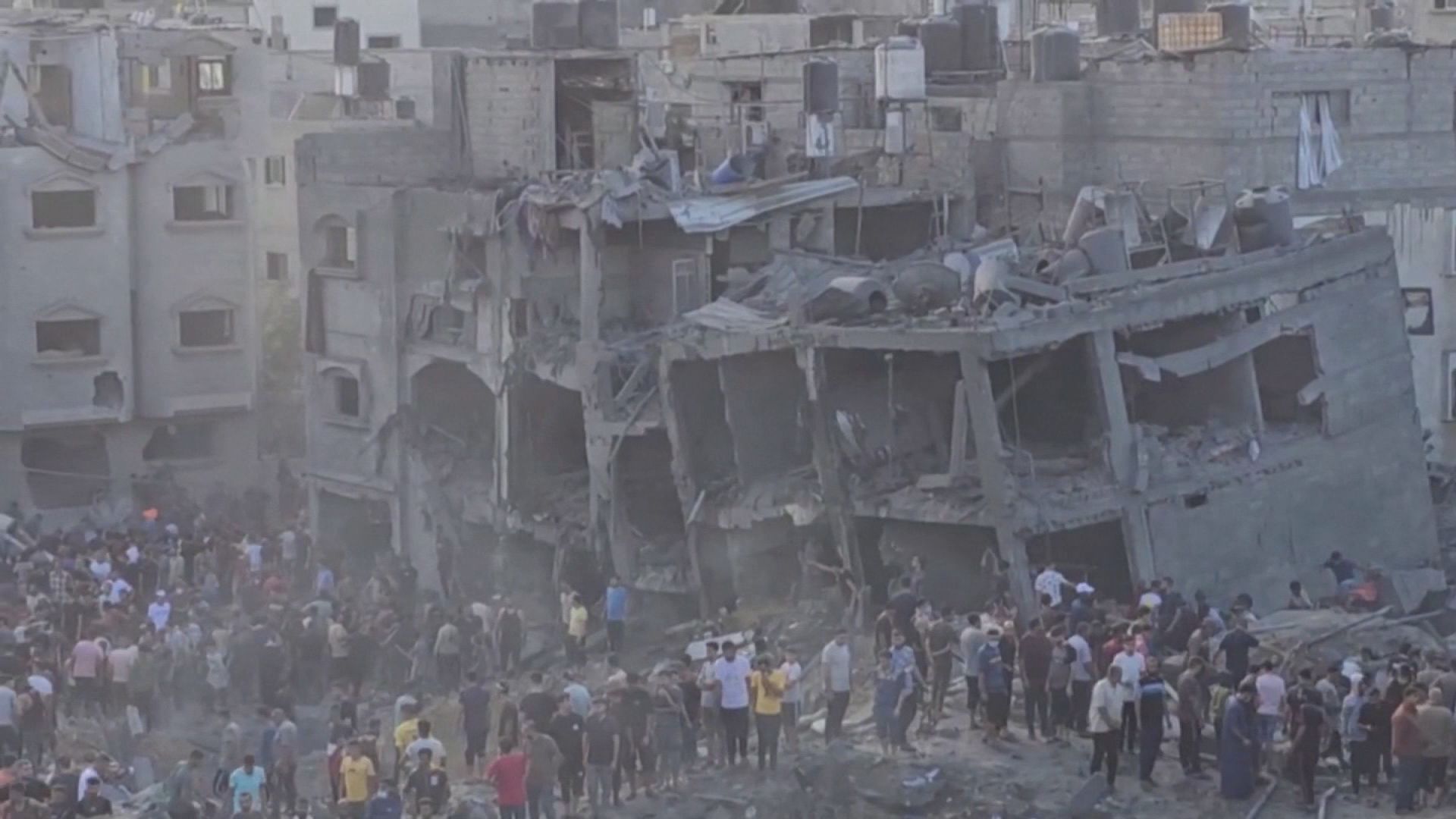People walk through a devastated street in Jabalia as aid schedules fluctuate