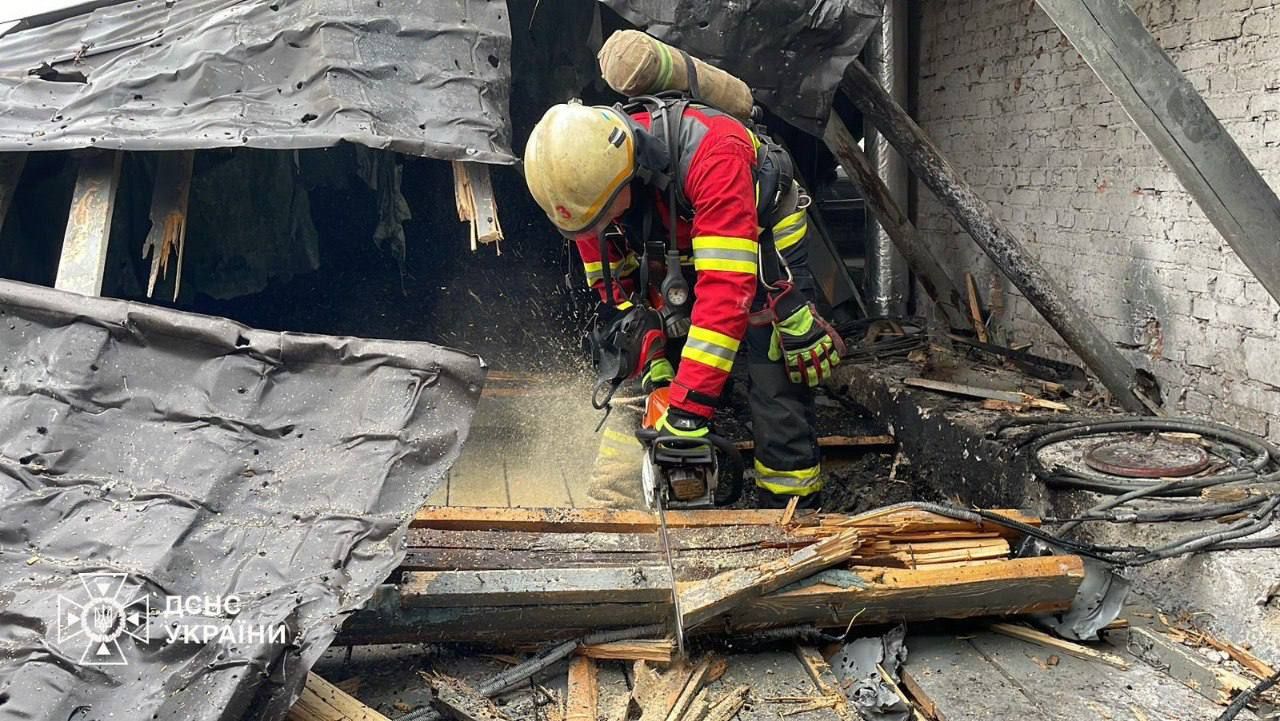 Emergency responders clear debris on the roof of a perinatal center in Sumy after a drone strike
