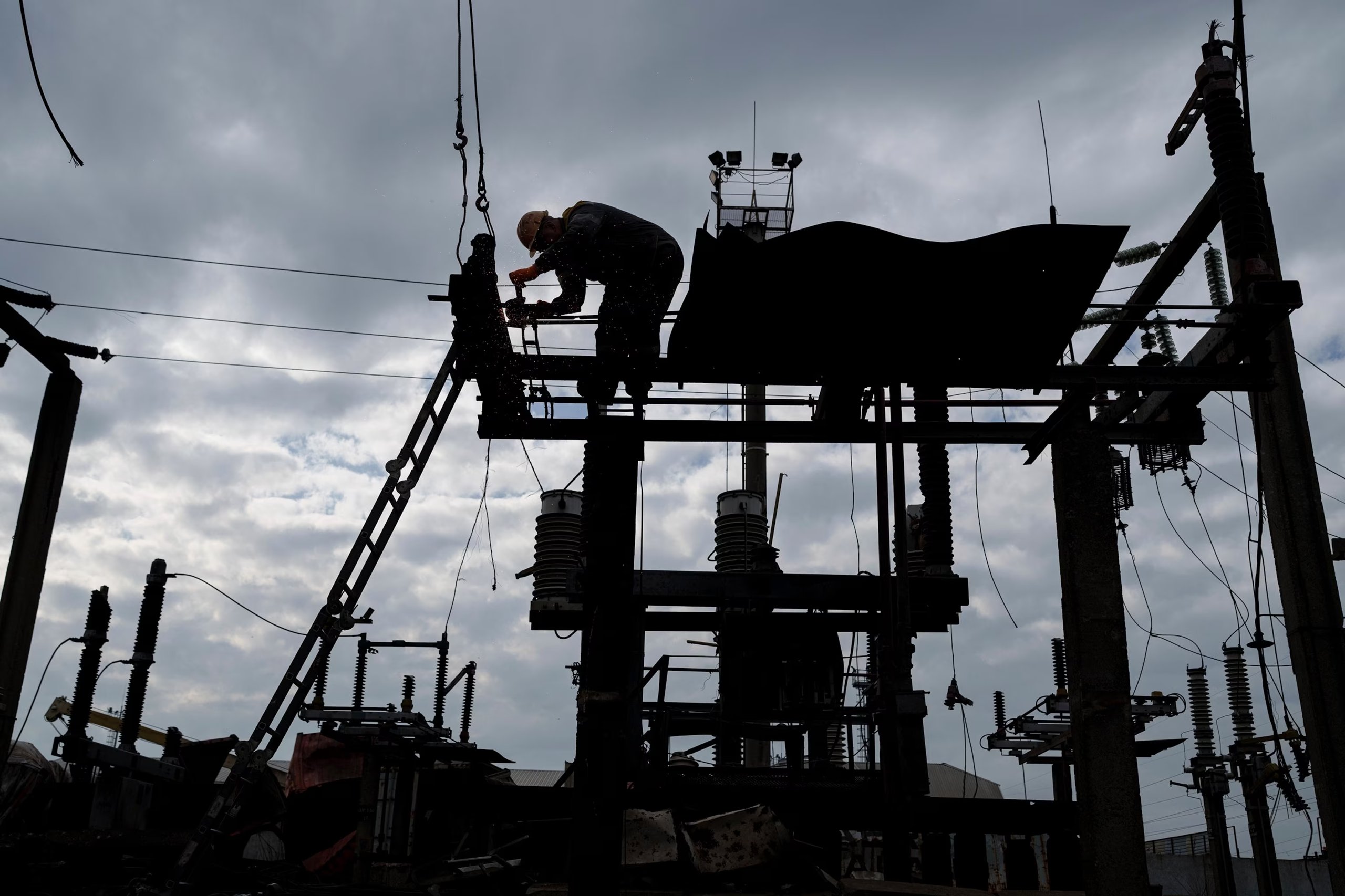Repair crews race to stabilize the grid Utility workers on a transformer platform in Kyiv repair infrastructure damaged by strikes